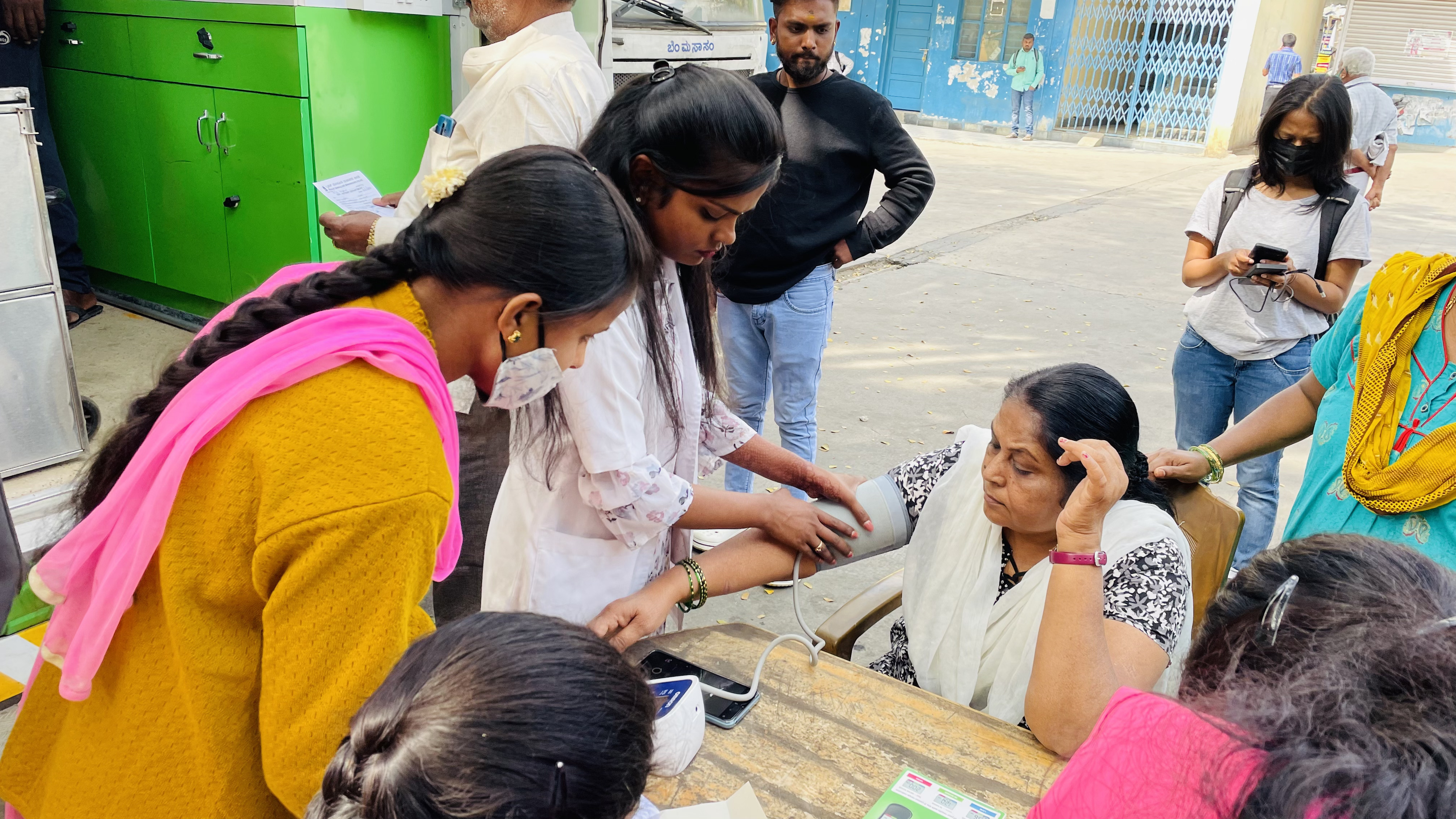 An Aahwahan volunteer checking a patient's blood pressure at a health camp