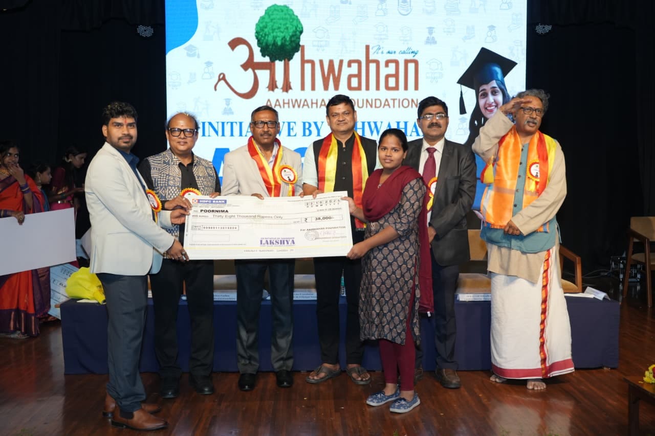 Scholarship recipients holding their award cheques at a Project Lakshya event