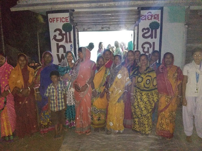 Women and children standing outside a village home